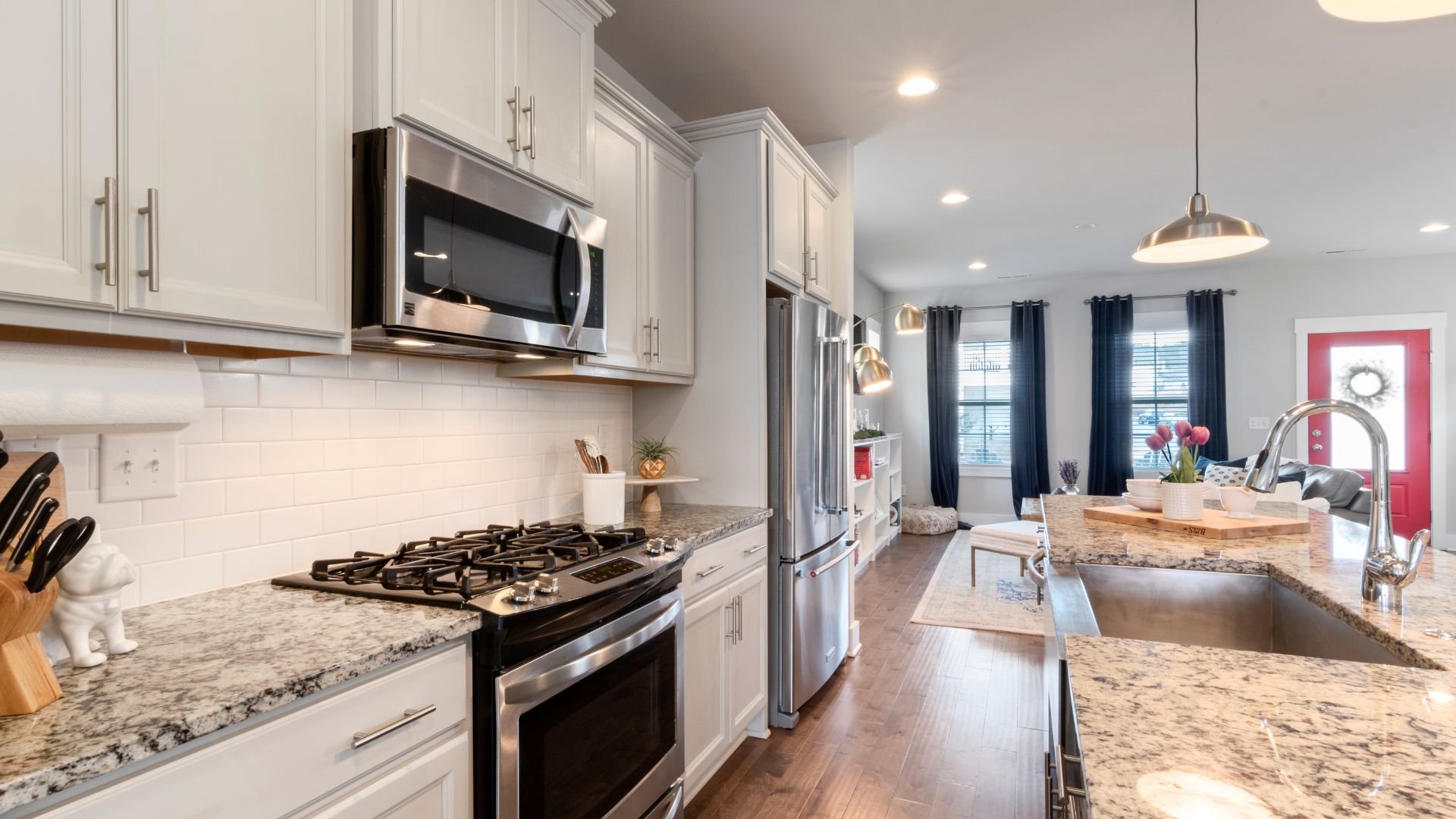Modern kitchen with white cabinets, granite countertops, and stainless steel appliances